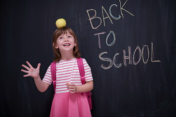 Image showing child holding apple on head