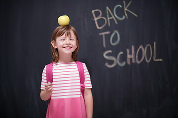 Image showing child holding apple on head