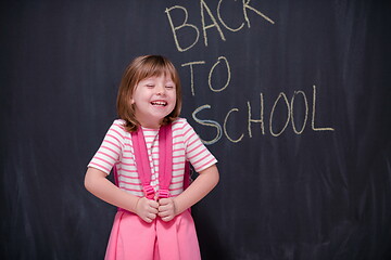 Image showing school girl child with backpack writing  chalkboard