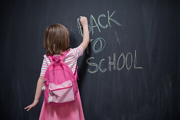 Image showing school girl child with backpack writing  chalkboard