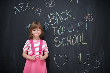 Image showing school girl child with backpack writing  chalkboard