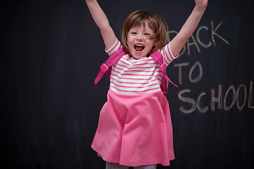 Image showing school girl child with backpack writing  chalkboard