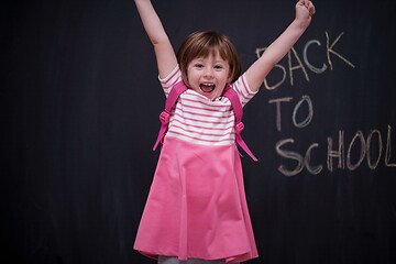 Image showing school girl child with backpack writing  chalkboard