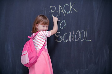 Image showing school girl child with backpack writing  chalkboard