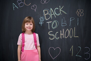 Image showing school girl child with backpack writing  chalkboard