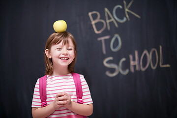 Image showing child holding apple on head