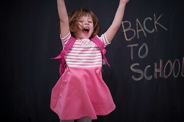 Image showing school girl child with backpack writing  chalkboard