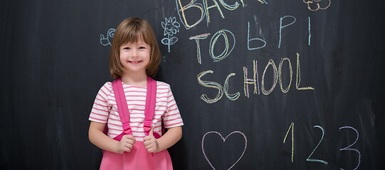 Image showing school girl child with backpack writing  chalkboard