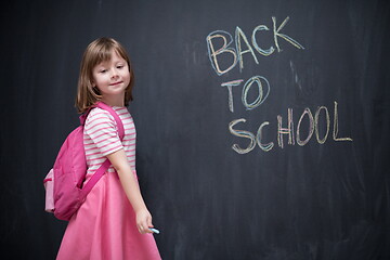 Image showing school girl child with backpack writing  chalkboard