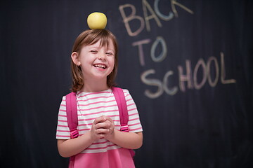 Image showing child holding apple on head