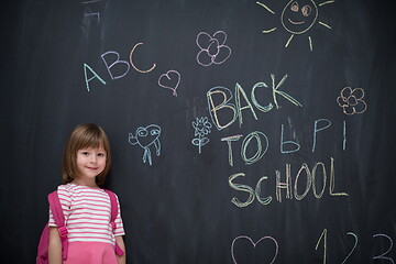 Image showing school girl child with backpack writing  chalkboard