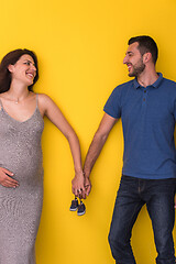 Image showing couple holding newborn baby shoes