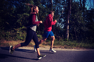 Image showing young couple jogging along a country road