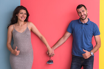 Image showing young happy couple holding newborn baby shoes