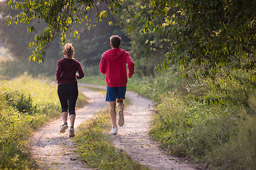 Image showing young couple jogging along a country road