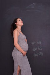 Image showing Portrait of pregnant woman in front of black chalkboard