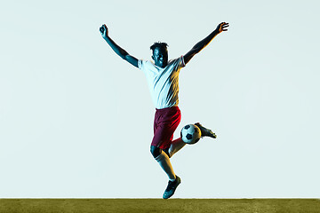 Image showing Male soccer player kicking ball isolated on white background