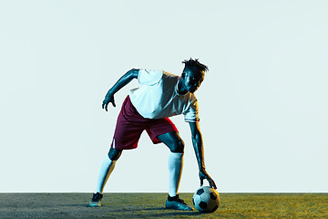 Image showing Male soccer player kicking ball isolated on white background