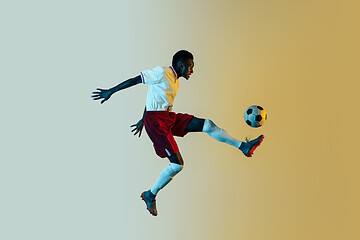 Image showing Male soccer player kicking ball in jump isolated on gradient background