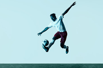 Image showing Male soccer player kicking ball isolated on white background