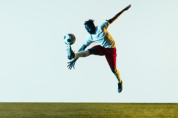 Image showing Male soccer player kicking ball isolated on white background