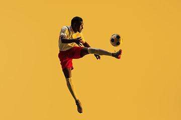 Image showing Male soccer player kicking ball in jump isolated on gradient background