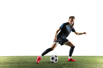 Image showing Female soccer player kicking ball isolated over white background