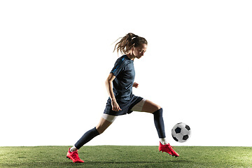 Image showing Female soccer player kicking ball isolated over white background