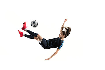 Image showing Female soccer player kicking ball isolated over white background