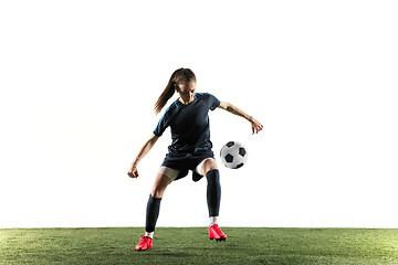 Image showing Female soccer player kicking ball isolated over white background