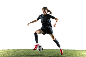 Image showing Female soccer player kicking ball isolated over white background