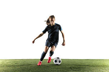 Image showing Female soccer player kicking ball isolated over white background