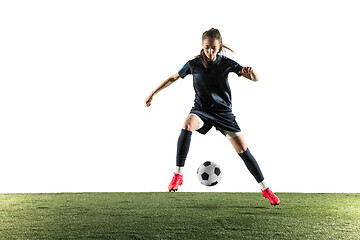 Image showing Female soccer player kicking ball isolated over white background