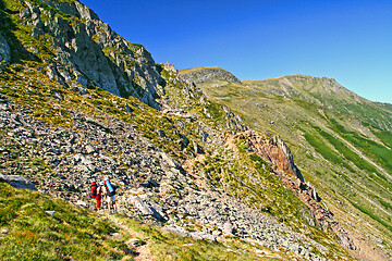 Image showing Summer mountain scene, hiking tourists on trail.
