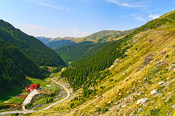 Image showing Green alpine valley, chalet near the forest