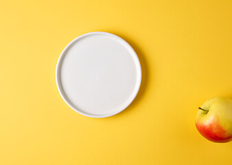 Image showing white plate and apple on yellow background