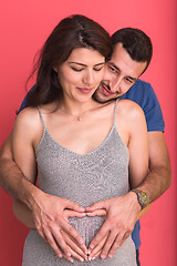 Image showing pregnant  couple showing heart with their hands