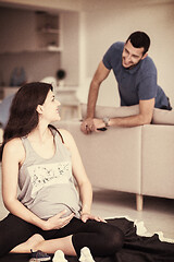 Image showing pregnant couple checking a list of things for their unborn baby