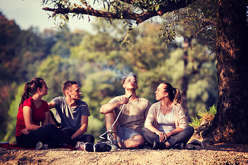 Image showing friends smoking hookah on the river bank