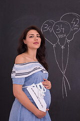 Image showing Portrait of pregnant woman in front of black chalkboard