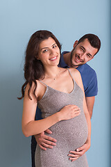 Image showing pregnant couple  isolated over blue background