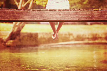 Image showing people sitting at wooden bridge