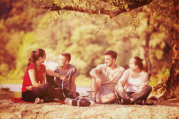 Image showing friends smoking hookah on the river bank