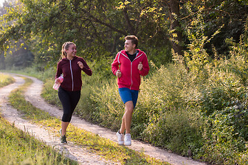 Image showing young couple jogging along a country road