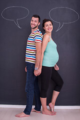 Image showing pregnant couple writing on a black chalkboard