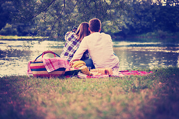 Image showing Couple taking a selfie by mobile phone while enjoying picnic tim