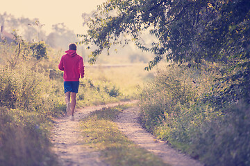 Image showing man jogging along a country road