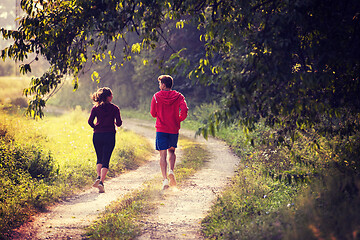 Image showing young couple jogging along a country road