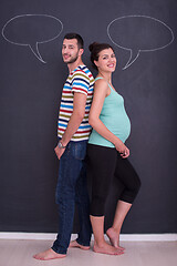 Image showing pregnant couple writing on a black chalkboard