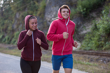 Image showing young couple jogging along a country road